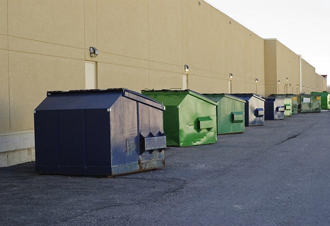 a series of colorful, utilitarian dumpsters deployed in a construction site in Bronxville